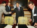 British Prime Minister Tony Blair stands aside as Russian President Valadimir Putin shakes hands with Mikhail Fridman, chairman of the Alfa group, as Lord Browne, right, CEO of BP, tidies up after signing a joint business deal in June 2003 during a Russia-UK energy summit in London.