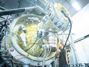 An employee works with General Fusion's P13 plasma injector, the world's most powerful plasma injector, at the company's Vancouver lab. The company is backed by Jeff Bezos and others.
