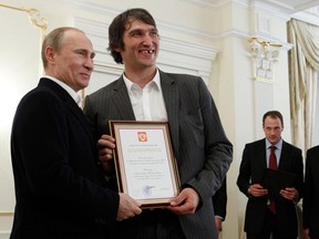 Der russische Präsident Wladimir Putin hält am 29. Mai 2012 in der Novo-Ogarevo-Residenz außerhalb von Moskau zusammen mit dem Mitglied der russischen Eishockeynationalmannschaft Alexander Ovechkin eine Urkunde.