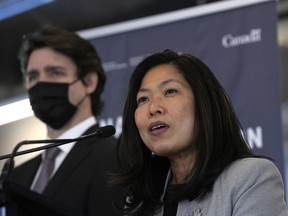 Minister of Economic Development Mary Ng speaks as Prime Minister Justin Trudeau listens at a news conference at Bayview Yards in Ottawa.
