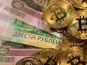 Russian rouble banknotes and representations of the cryptocurrency Bitcoin.
