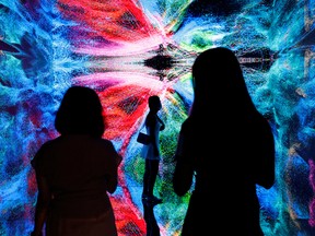 Visitors in front of an immersive art installation titled 'Machine Hallucinations - Space: Metaverse' by media artist Refik Anadol at the Digital Art Fair, in Hong Kong, China.