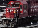 A Canadian Pacific Railway employee walks along the side of a locomotive in a marshalling yard in Calgary.