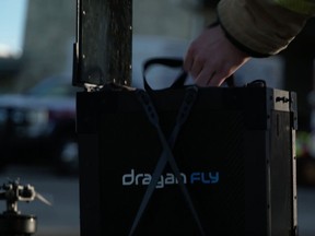 A humanitarian worker picks up a Draganfly drone medical payload.