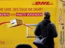 A man passes a DHL truck in Berlin, Germany.