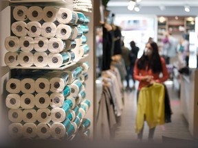 Customers shop in Norbert Kremsreiter's fashion store, which originally sells clothes and food, and recently toilet paper and other toiletries, in Freyung, Germany.