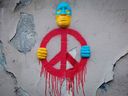 Eine Installation des Straßenkünstlers Gregos in Paris, die ein Gesicht in den Farben der Ukraine darstellt, das ein Symbol des Friedens in seinen Händen hält, während die Welt auf die russische Invasion reagiert.