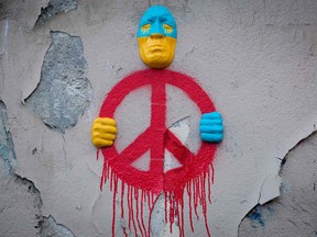 An installation by street artist Gregos in Paris representing a face in the colours of Ukraine holding a symbol of peace in his hands as the world reacts to Russia's invasion.