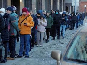 People stand in line to use an ATM money machine in Saint Petersburg, Russia, Feb. 27, 2022.