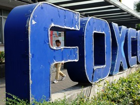 In a photo taken on Feb. 22, 2013, a young man walks past a Foxconn recruitment point in Shenzhen.