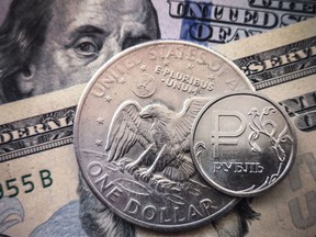 Russische Rubelmünze ist mit US-Dollar-Scheinen und einer Ein-Dollar-Münze in Moskau abgebildet.