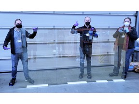 Image of Ubiquitous Energy team holding 1.5 x 3.0 meter size glass coated with one of Ubiquitous Energy's UE Power™ transparent solar materials