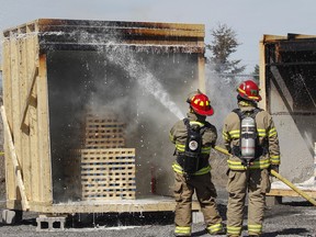 Representatives from FireRein demonstrate how quickly the company’s new gel additive, Eco-Gel, can put out a a standard wood fire and not re-ignite.