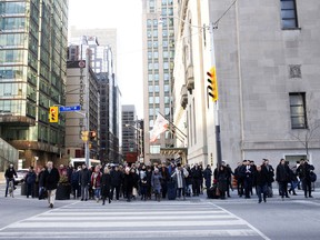 Pedestrians cross Front Street in the financial district of Toronto.