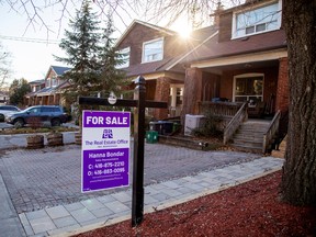 A for sale sign outside a home in Toronto.