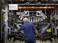 An employee assembles a bumper at the Magna International Inc. Polycon Industries auto parts manufacturing facility in Guelph, Ont.