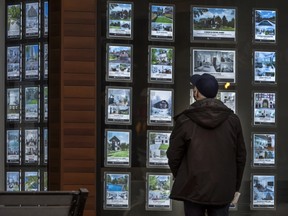 Eine Person sieht sich Immobilienbulletins in Toronto an.