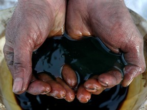 An employee holds a sample of crude oil at the Yarakta oilfield in the Irkutsk region of Russia.
