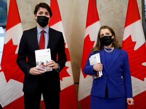Prime Minister Justin Trudeau and Finance Minister Chrystia Freeland pose for a picture holding the 2022-23 budget.