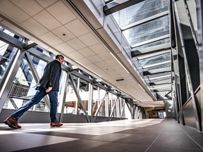 Ein Büroangestellter in der Innenstadt geht durch eine ruhige Plus-15-Überführung in der Innenstadt von Calgary.