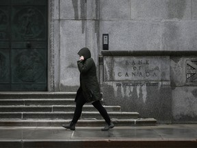 A pedestrian walks by the Bank of Canada building in Ottawa.