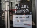 A sign advertising open jobs at the Gamestop store.