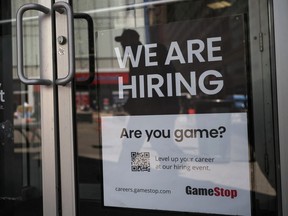 A sign advertising open jobs at a GameStop store.