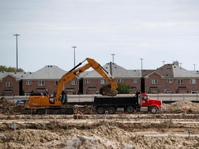 Construction workers build homes on a lot in Vaughan.