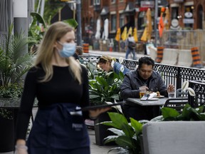 People sit on an outdoor patio in Toronto.
