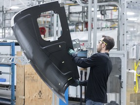 A worker inspects the door of a helicopter at a Bell Helicopter Textron Canada manufacturing facility in Mirabel, Que.