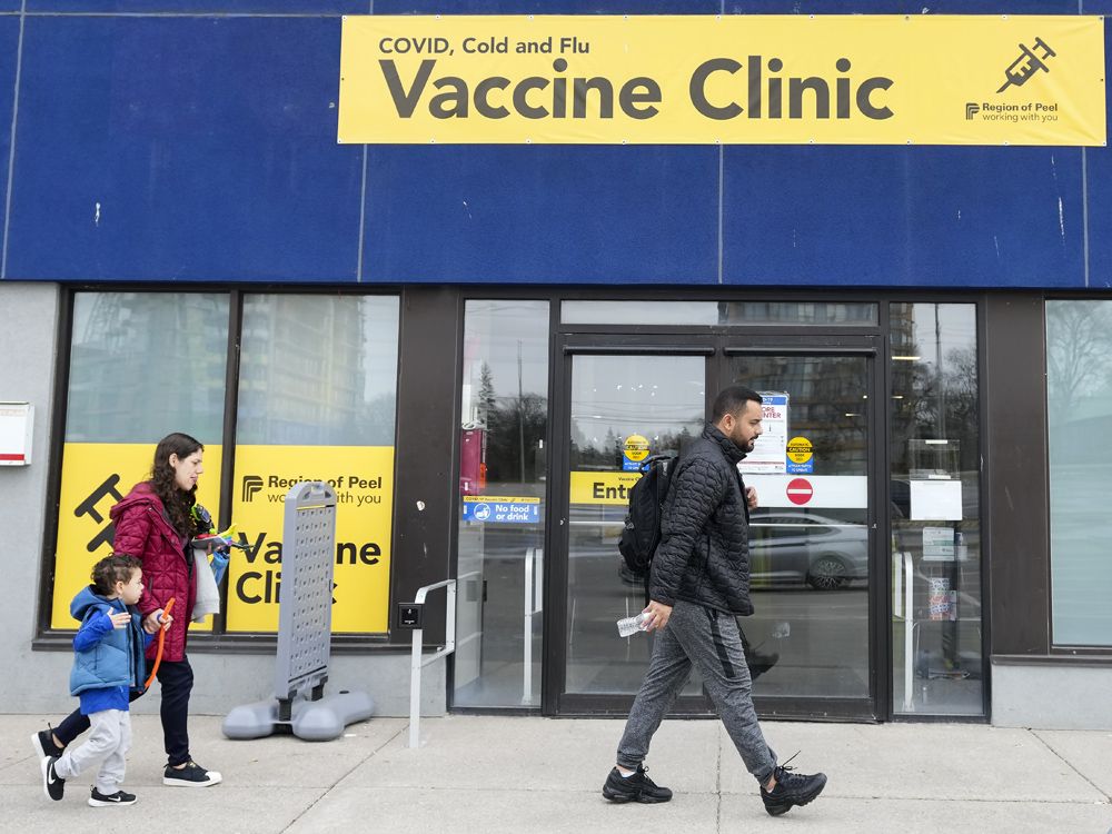 People walk past a vaccine clinic during the COVID-19 pandemic in Mississauga, Ont.