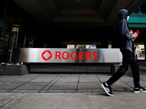 A person walks near the Rogers Communications building in Toronto.