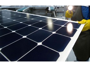 An employee of SunPower Corp. trims the edges and checks solar panels at the SunPower Corp. module manufacturing plant at Flextronics in Milpitas, California, U.S., on Wednesday, Aug. 24, 2011.