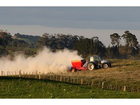 MORRINSVILLE, NEW ZEALAND - APRIL 18: A tractor spreads fertiliser at a dairy farm on April 18, 2012 in Morrinsville, New Zealand. Raw milk sales are growing as more people are educating themselves on what they believe healthy food is.