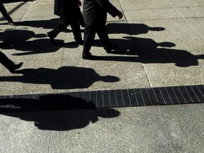 Businessmen cast their shadows as they walk in Toronto's financial district on Monday, Feb. 27, 2012. A new study shows Canadian employers are willing to hire workers without experience related to the job due to a tight labour market.