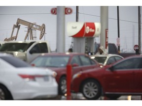 An electric oil pump jack stands past a gas station in Midland, Texas, U.S., on Wednesday, Nov. 8, 2017. Nationwide gross oil refinery inputs will rise above 17 million barrels a day before the year ends, according to Energy Aspects, even amid a busy maintenance season and interruptions at plants in the U.S. Gulf of Mexico that were clobbered by Hurricane Harvey in the third quarter. Photographer: Luke Sharrett/Bloomberg