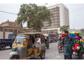 Traffic moves past the State Bank of Pakistan building in Karachi, Pakistan, on Thursday, July 26, 2018. Former cricket star Imran Khan was close to winning an outright majority in Pakistan's election as his main political rivals complained of vote rigging in a contest already tarnished by violence and allegations of army interference.
