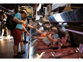 Customer browse meats at the Granville Island Public Market in Vancouver.