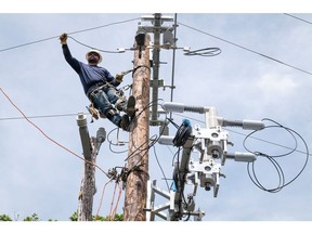 A Pacific Gas & Electric Co. worker moves a wire into place while installing a bypass switch in Yountville, California in April 2020.