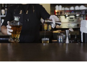 A bartender wearing protective gloves pours a shot of mezcal at Hugo's restaurant in Houston, Texas, U.S., on Wednesday, May 20, 2020. Americans locked at home for more than two months seem resigned to participating in a coronavirus experiment that begins in earnest this Memorial Day weekend, with all 50 states open at least in part.