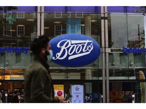 A pedestrian wearing a protective face mask passes a Boots pharmacists, operated by Walgreens Boots Alliance Inc., on Oxford Street in London, U.K., on Thursday, July 9, 2020. British shops aren't getting much of a boost from newly reopened bars, cafes and restaurants as customers prefer to stay away. Photographer: Simon Dawson/Bloomberg