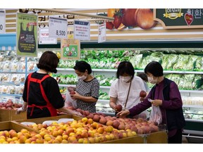 Customers wear protective masks while shopping for apples at a Hanaro Mart supermarket, operated by the National Agricultural Cooperative Federation (Nonghyup), in the Seocho district of Seoul, South Korea, on Friday, Aug. 20, 2021. Focus is growing on whether the Bank of Korea can take the country's worst-ever virus wave in stride and tighten monetary policy on Aug. 26. Photographer: SeongJoon Cho/Bloomberg