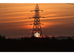 The sun rises beyond an electricity transmission tower near Rayleigh, U.K. Photographer: Chris Ratcliffe/Bloomberg