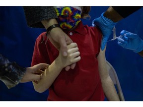 A healthcare worker administers a dose of the Pfizer-BioNTech Covid-19 vaccine to a child at a Salvation Army vaccination clinic in Philadelphia, Pennsylvania, U.S., on Friday, Nov. 12, 2021. The Pfizer-BioNTech Covid-19 vaccines for children ages 5 to 11-year-old are a third of the dose that adults receive. Photographer: Hannah Beier/Bloomberg