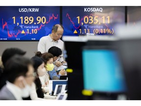 Foreign currency dealers work in front of monitors displaying the exchange rate between the South Korean won and U.S. dollar, left, and the Korean Securities Dealers Automated Quotations (Kosdaq) in a dealing room of Hana Bank in Seoul, South Korea, on Monday, Jan. 3, 2022. South Korea's Kospi advanced as much as 1.1% on the first trading day of 2022 on foreign purchases. It's poised for the first gain in three sessions. Photographer: SeongJoon Cho/Bloomberg