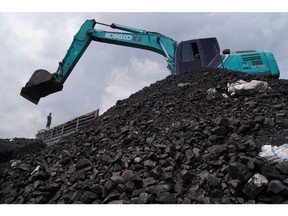 An excavator sits on a pile of coal at Karya Citra Nusantara (KCN) Marunda Port in Jakarta, Indonesia, on Wednesday, Jan. 19, 2022. Indonesia, the top thermal coal exporter, will keep a broad ban on January shipments in place even as exemptions have allowed some fuel-laden vessels to depart. Photographer: Dimas Ardian/Bloomberg