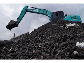 An excavator sits on a pile of coal at Karya Citra Nusantara (KCN) Marunda Port in Jakarta, Indonesia, on Wednesday, Jan. 19, 2022. Indonesia, the top thermal coal exporter, will keep a broad ban on January shipments in place even as exemptions have allowed some fuel-laden vessels to depart. Photographer: Dimas Ardian/Bloomberg