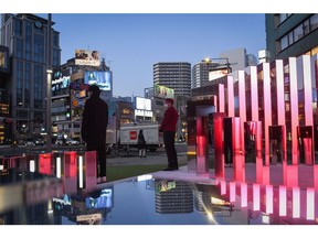 Buildings are reflected in water from a fountain in the Omotesando district of Tokyo, Japan, Saturday, Feb. 12, 2022. Footfall has returned to Tokyo's shopping districts since the lifting of states of emergency that were in place for most of 2021. With international travel still a problem for most Japanese due to long quarantine periods on return, more and more shoppers are now spending at home on luxury handbags, watches and fashion. Photographer: Noriko Hayashi/Bloomberg