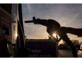 A driver holds a fuel nozzle at a gas station in Sacramento, California, U.S., on Thursday, March 24, 2022. California Governor Gavin Newsom is proposing to send car owners $400 debit cards and partially pause gasoline taxes to address high gas prices.