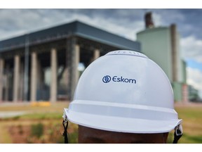 A visitor wears a branded hard hat during a media tour of the Eskom Holdings SOC Ltd. Medupi coal-fired power station in Lephalale, South Africa, on Thursday, May 19, 2022. South Africa's Eskom is increasing power cuts to prevent a total collapse of the grid as issues grow from lack of imports to breakdowns at its coal-fired plants. Photographer: Waldo Swiegers/Bloomberg